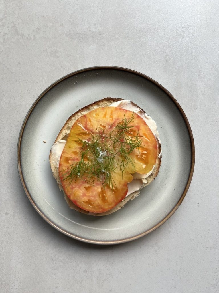 sesame bagel with heirloom tomato